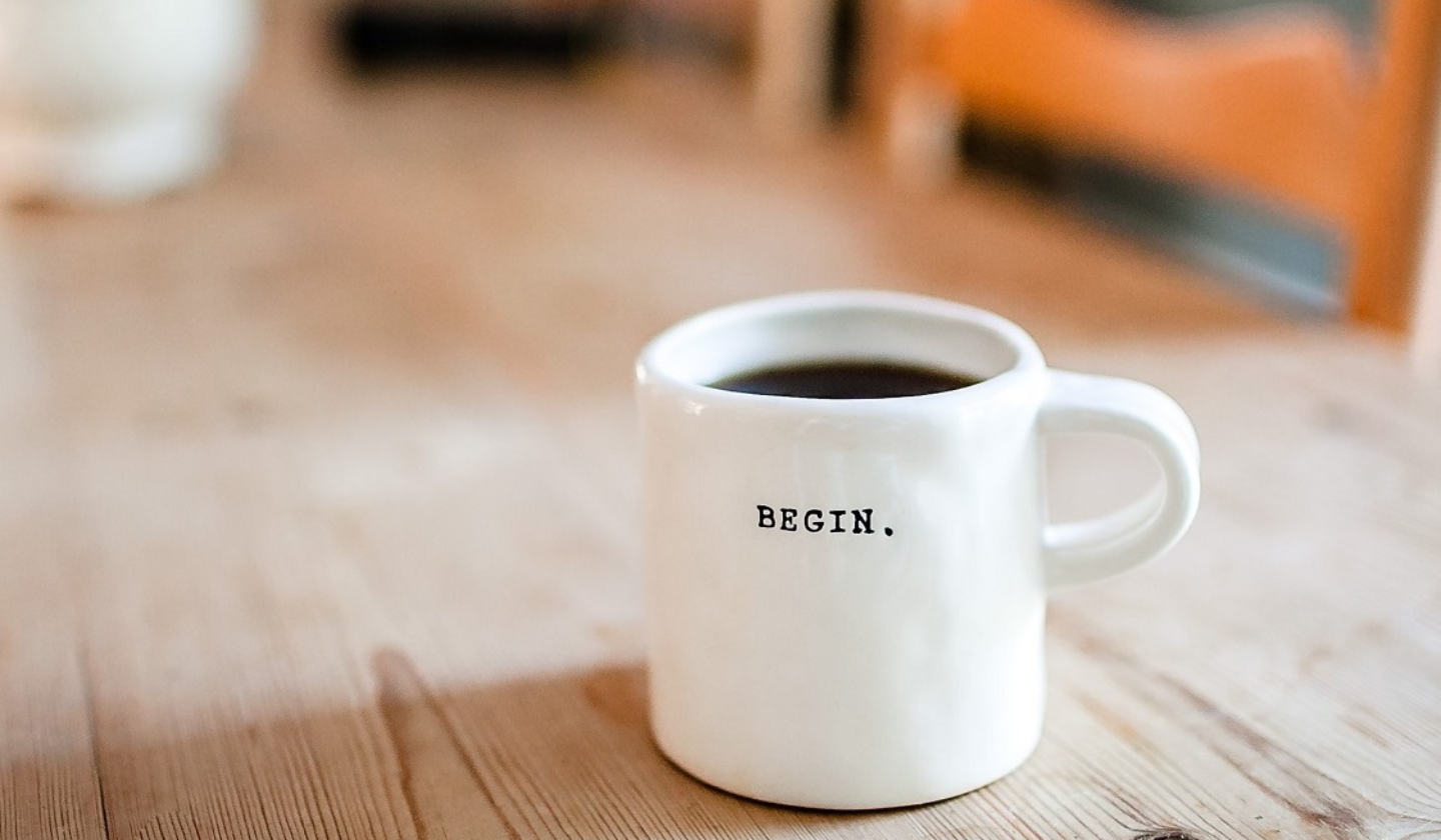 Witte mok met koffie op een houten tafel